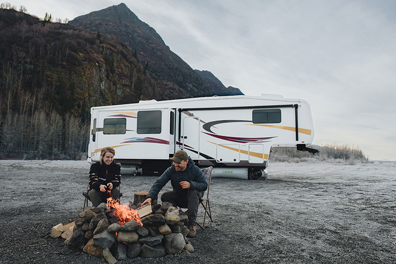 Couple by fire staying warm with RV Skirting