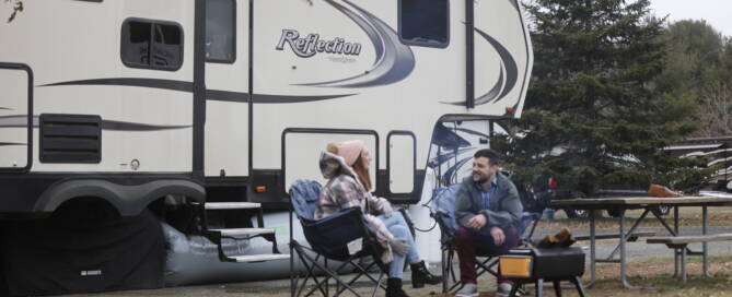 couple in front of rv fifth wheel before measuring length